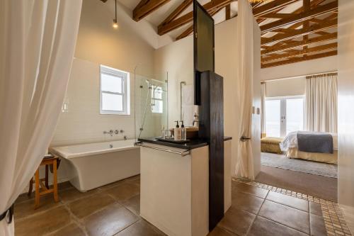 a bathroom with a bath tub and a sink at The Lofts Boutique Hotel in Knysna