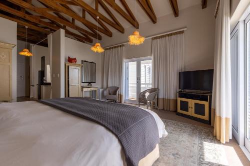 a bedroom with a large bed and a flat screen tv at The Lofts Boutique Hotel in Knysna