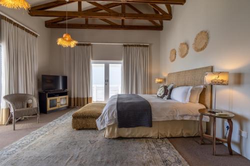 a bedroom with a large bed and a tv at The Lofts Boutique Hotel in Knysna