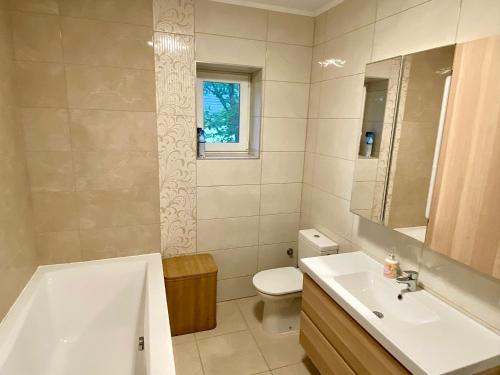 a bathroom with a sink and a tub and a toilet at Hilltop Apartments in Fonyód