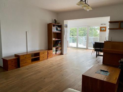 a living room with wooden floors and a room with a table at Hilltop Apartments in Fonyód