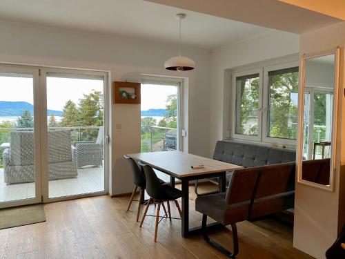 a dining room with a table and chairs and a balcony at Hilltop Apartments in Fonyód