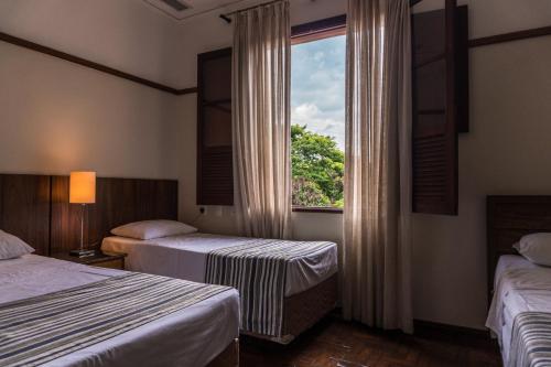 a hotel room with two beds and a window at Hotel Nacional Inn Araxá Previdência in Araxá