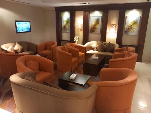 a living room with couches and chairs and a tv at نسيم العليا in Al Khobar