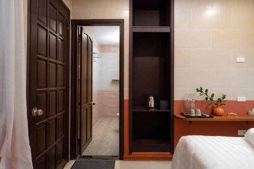 a bedroom with a door leading to a bathroom at Hoianese Center Hotel - Truly Hoi An in Hoi An