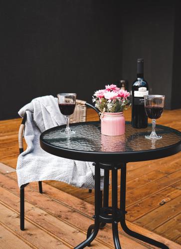 a black table with two glasses of wine and flowers at Hotel Darchi Kazbegi in Stepantsminda