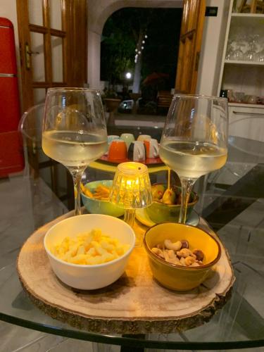 two glasses of wine and bowls of food on a table at Villa Anna GuestHouse in Brindisi