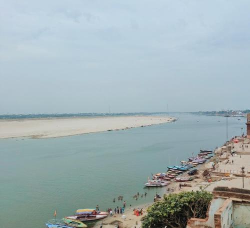 a group of boats are lined up on a beach at Hotel Shannti Inn in Varanasi