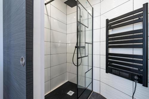 La salle de bains est pourvue d'une douche avec une porte en verre. dans l'établissement Dijon centre historique, superbe studio à 2 pas des trams, à Dijon