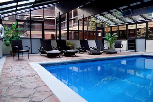 a swimming pool with chairs and a building at Park Regency in Park City