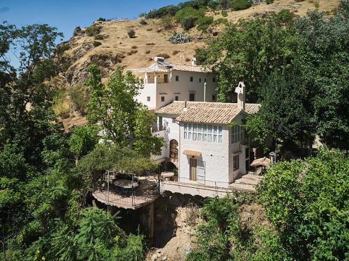 a house on the side of a mountain at El Molino in Cazorla