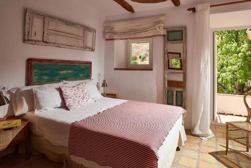 a bedroom with a bed and two windows at El Molino in Cazorla