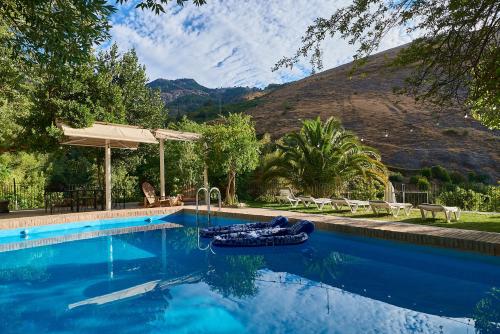 a swimming pool with a raft in front of a mountain at El Molino in Cazorla
