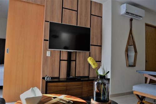 a living room with a tv on a wall at Steps from the Beach Condo Life Bucerias Golden Zone in Bucerías
