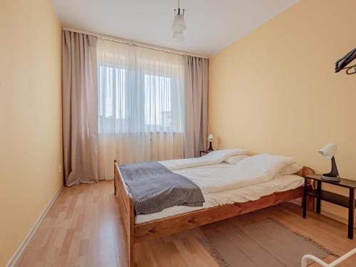 a bedroom with a bed and a large window at Mieszkanie Centrum in Iława