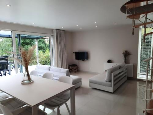 a living room with white furniture and a table at Holiday Home Mooi-Gemmenich in Plombières