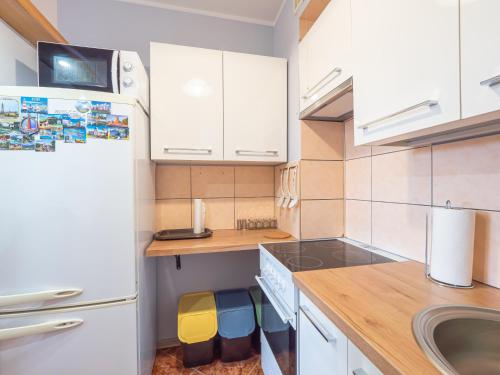 a kitchen with white cabinets and a white refrigerator at Mieszkanie Centrum in Iława
