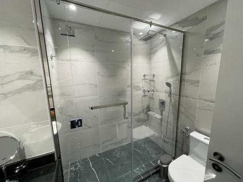 a bathroom with a shower with a toilet and a sink at Birchfort - Newly renovated unique 1 bedroom apartment in Dubai