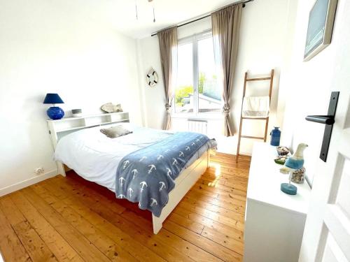 sypialnia z łóżkiem i drewnianą podłogą w obiekcie Très jolie Villa Bianca, maison avec jardin privé à Deauville w mieście Deauville