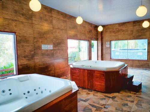 a large bathroom with a bath tub and a tub at Hotel Fazenda Golden Park Campos do Jordão in Campos do Jordão