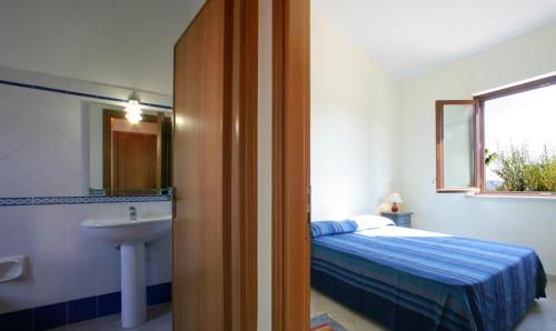 クストナーチにあるVilla Alle Falde di Cofanoのベッドルーム(ベッド1台、シンク、鏡付)