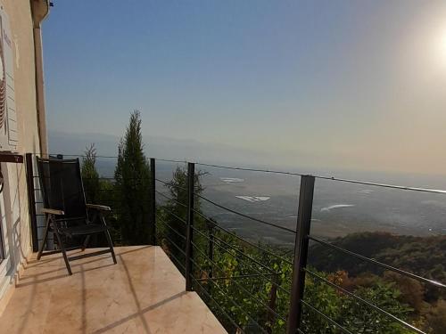 a balcony with a chair and a view of the ocean at Abramichi Guest House in Sighnaghi