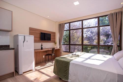 a bedroom with a white bed and a large window at GoÁtica Aeroporto Congonhas in Sao Paulo