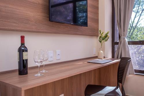 a bottle of wine and two wine glasses on a counter at GoÁtica Aeroporto Congonhas in Sao Paulo