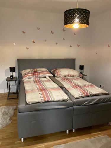 a bed sitting in a bedroom with a lamp at Freiblick 1 Bad Glbg mit Garten Top1 in Bad Gleichenberg