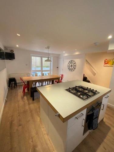 - une cuisine et une salle à manger avec une cuisinière et une table dans l'établissement Beachside House, à Brighton et Hove