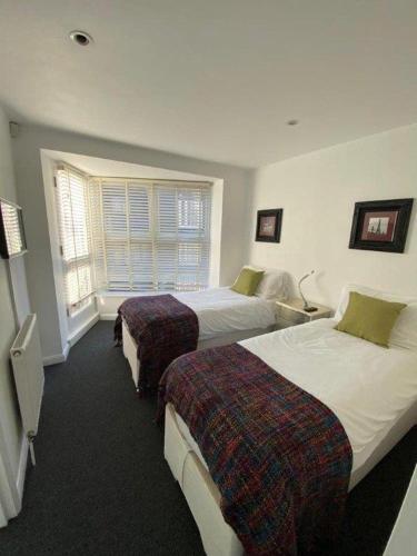 Habitación de hotel con 2 camas y ventana en Beachside House, en Brighton & Hove
