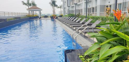 a hotel swimming pool with lounge chairs and a gazebo at Pasay Coast Residences JCMJ in Manila