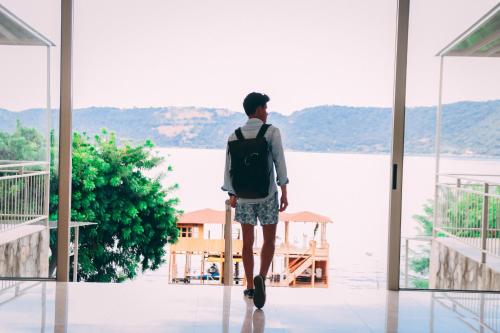 a man with a backpack looking out at the water at Equinoccio Hotel in Santa Ana