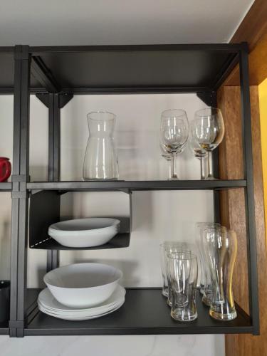 a shelf with plates and wine glasses on it at A Casiña do Camiño in Baamonde