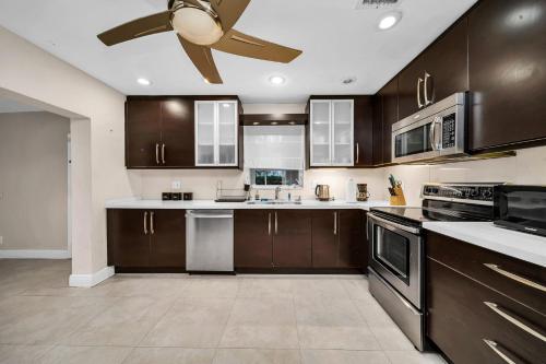 a kitchen with brown cabinets and a ceiling fan at Pool House on the Water 2 in Miami