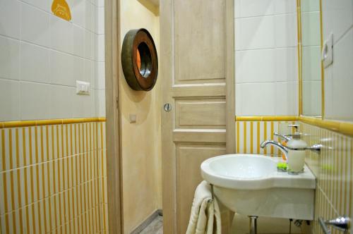 een badkamer met een witte wastafel en een spiegel bij Sleeppo B&B in Rome