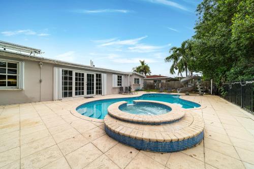 a swimming pool in front of a house at Pool House on the Water 2 in Miami