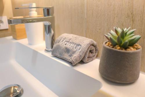 a bathroom counter with a towel and a potted plant on it at Iconic Sea Views Luxury Apartment in Puerto Marino