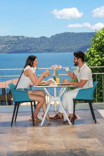 a man and woman sitting at a table drinking coffee at Equinoccio Hotel in Santa Ana