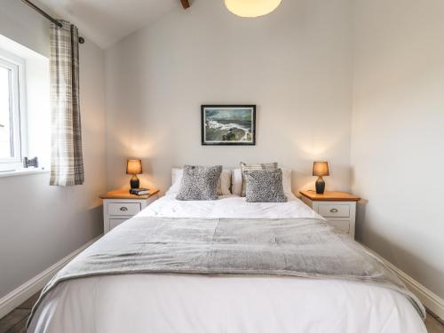 a bedroom with a large bed with two night stands at Wagtail Cottage in Mablethorpe