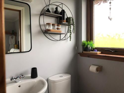 a bathroom with a sink and a toilet and a mirror at Aurora in Ose