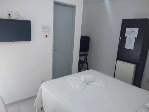 Cette chambre dispose d'un lit blanc et d'un oriel. dans l'établissement Pousada Nascer do Sol, à João Pessoa