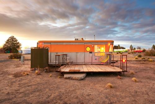 an orange and white trailer parked in a field at El Cosmico in Marfa
