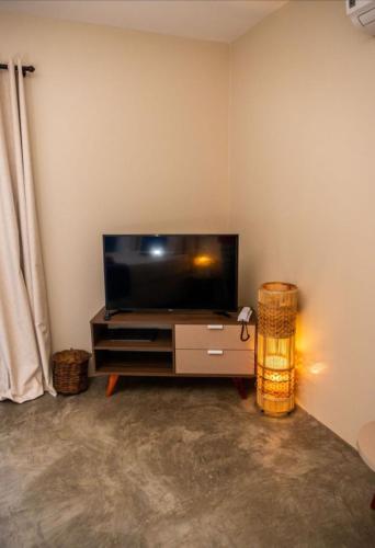 a living room with a flat screen tv on a wall at Villa Zen Hotel in Camocim