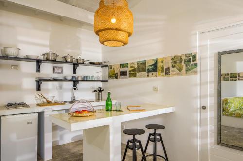 a kitchen with white walls and a counter with stools at El Encuentro Surf Lodge in Cabarete