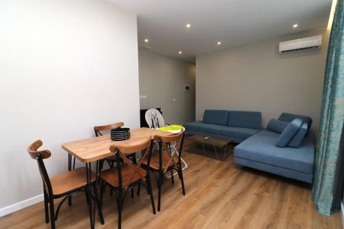 a living room with a table and a blue couch at Vila ELARAD in Vlorë