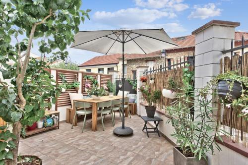 a patio with a table and an umbrella at Beautiful house with terrace - Puteaux - Welkeys in Puteaux