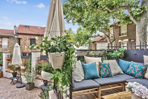 a patio with a blue couch and an umbrella at Beautiful house with terrace - Puteaux - Welkeys in Puteaux