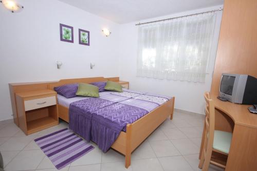 a bedroom with a bed and a desk and a tv at Apartments by the sea Slano, Dubrovnik - 8608 in Slano