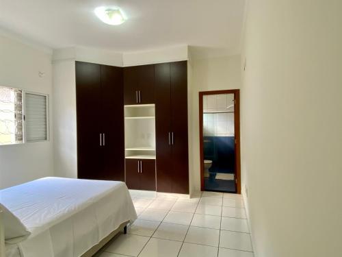 um quarto com uma cama e armários castanhos em Área Central/3 quartos/grande grupos em Marília